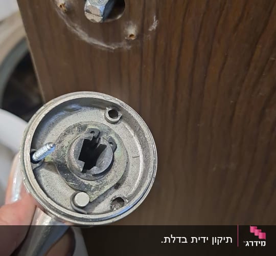 ידית דלת מתכתית מפורקת עם חור בדלת עץ